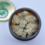 Z Face cannabis buds in a jar with golden lid and green sprout logo